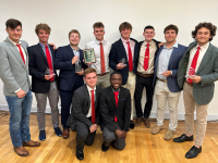 Phi Sigma Kappa group photo holding all the awards they won. 